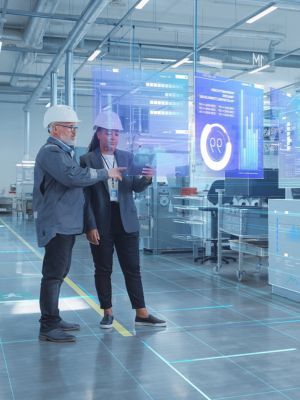 Two people standing inside a manufacturing industrial warehouse